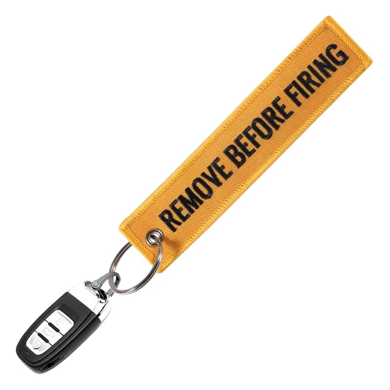 Cross border hot sale in stock wholesale orange black word REMOVE BEFORE FIRING embroidery gift keychain