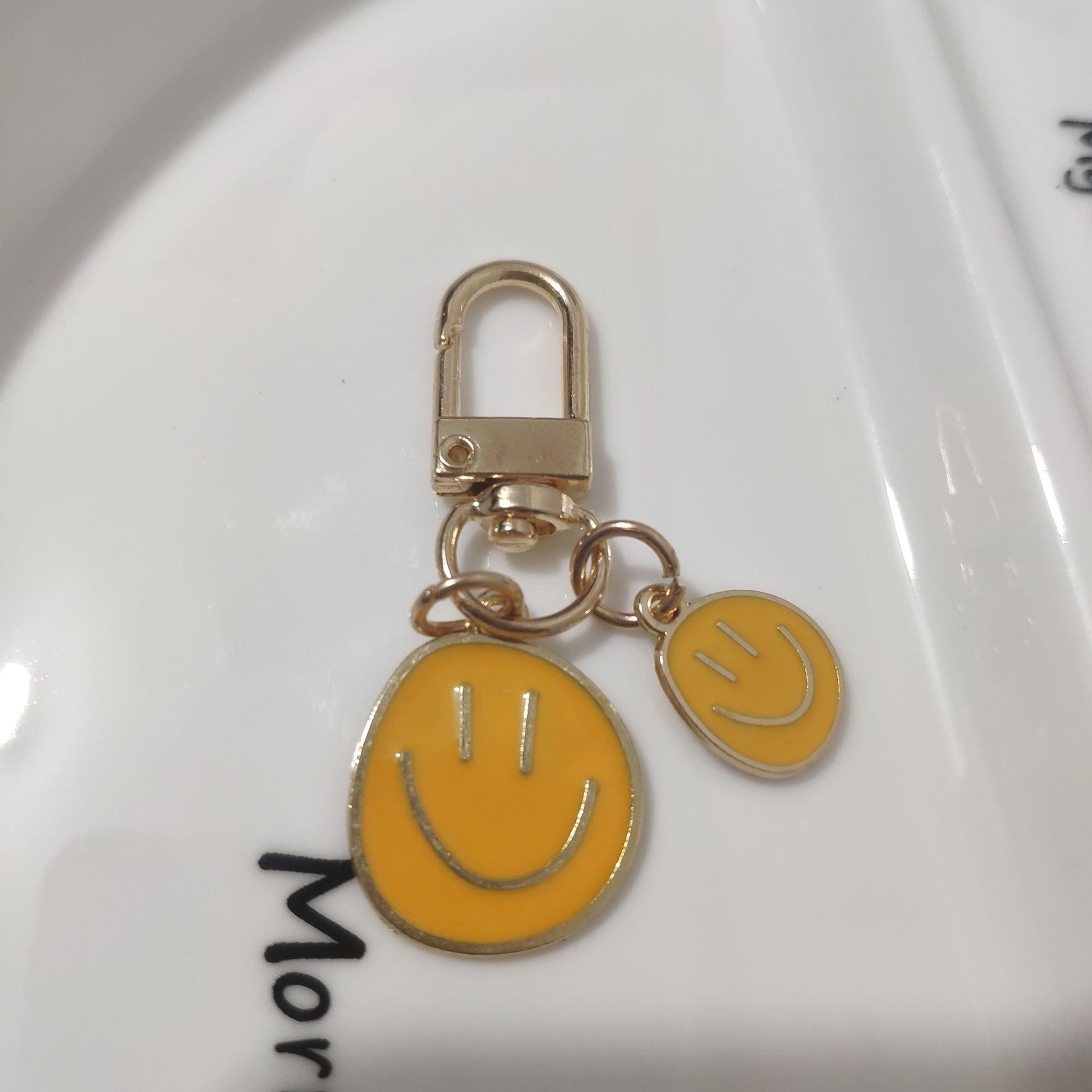 Picture of Cross-border e-commerce alloy color dripping smiley face keychain electroplated gold irregular expression bag pendant accessories